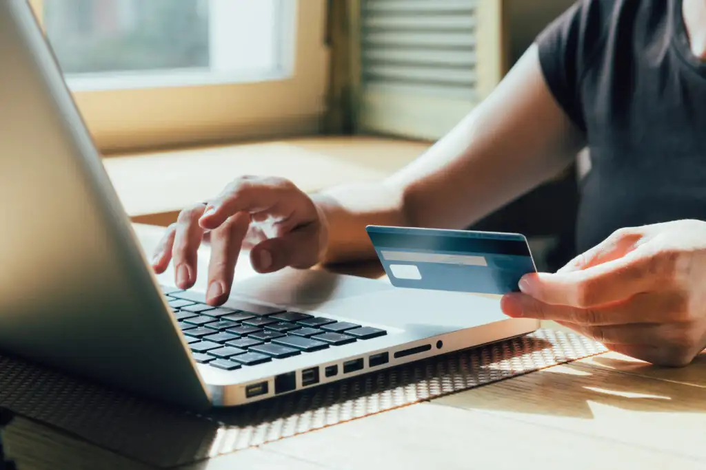 Close up of a person making a credit card purchase on a laptop