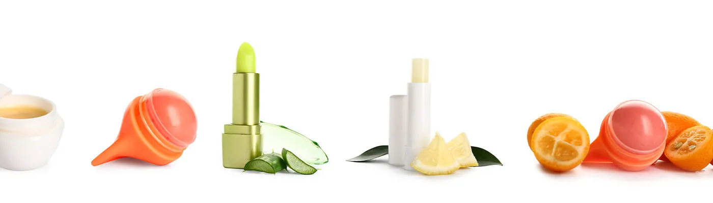 Set of different lip balms on white background