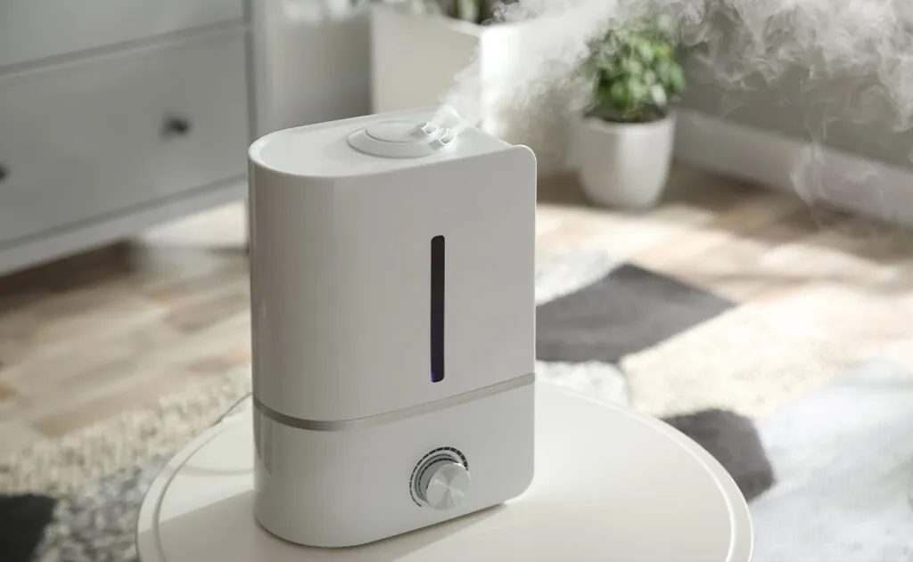 Modern air humidifier on table at home